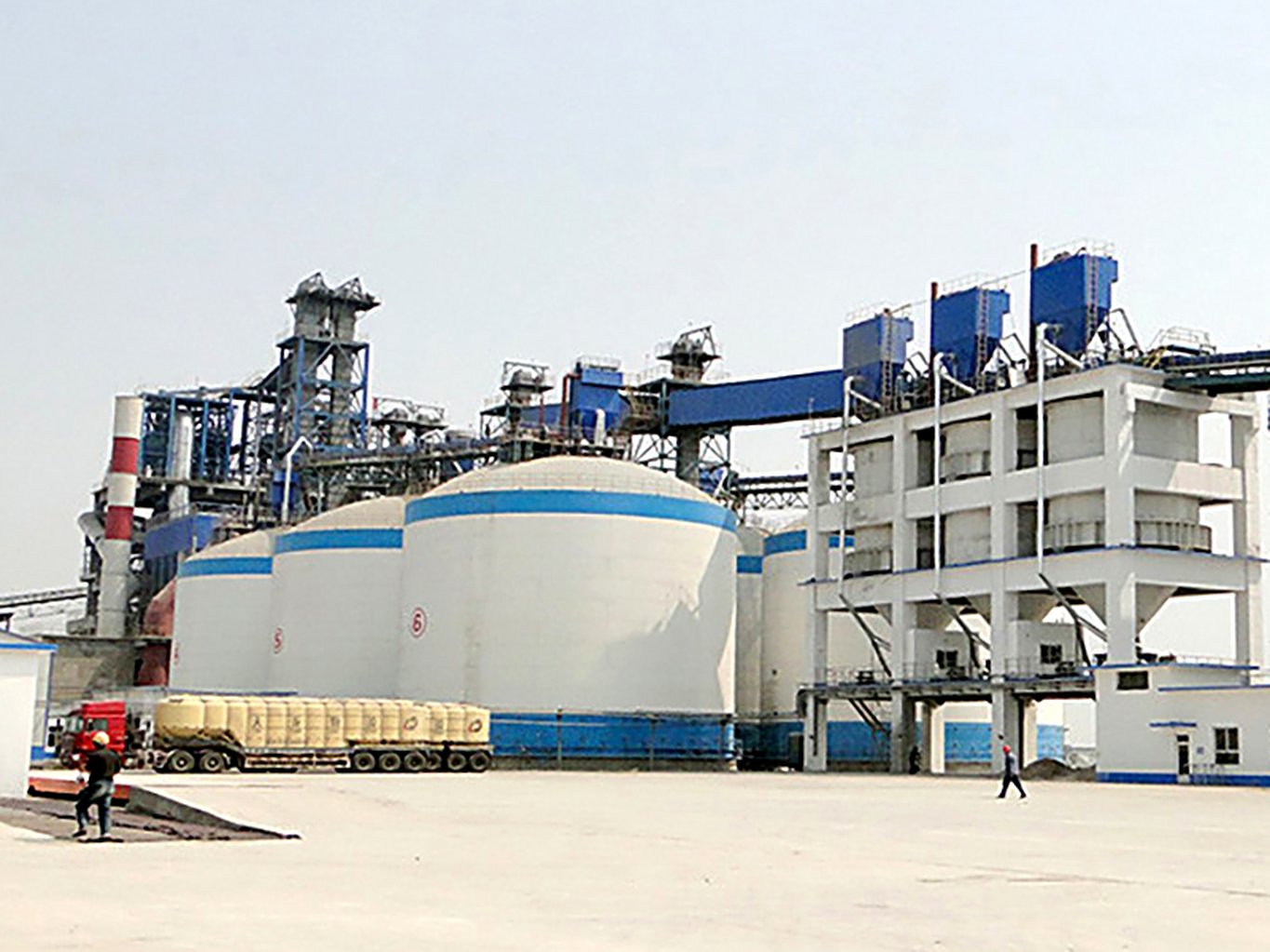 Welded steel fly ash silos with dust collection and conveying towers at a cement plant
