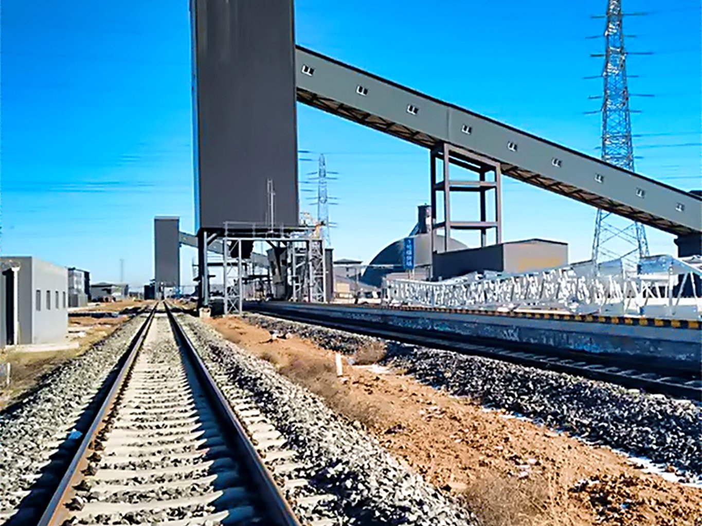 Rail loading tower and covered conveying gantry at a bulk cement dispatch terminal